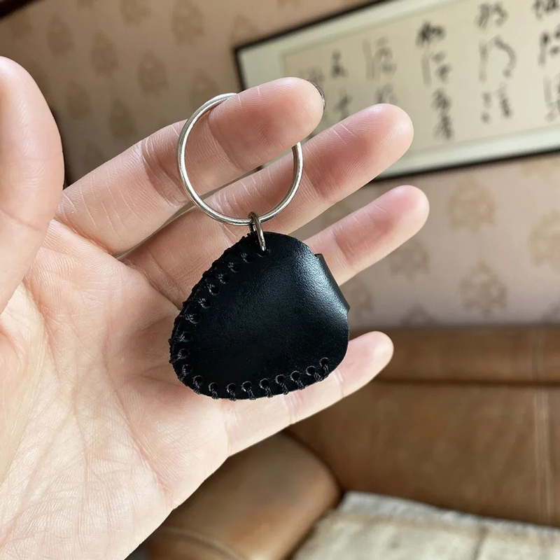 Cara trasera de un llavero de guitarra hecho de cuero auténtico con estuche para púas