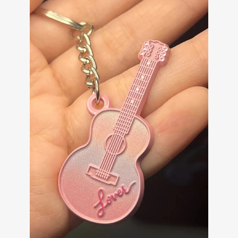 Portachiavi a forma di chitarra di colore rosa con la scritta "Lover