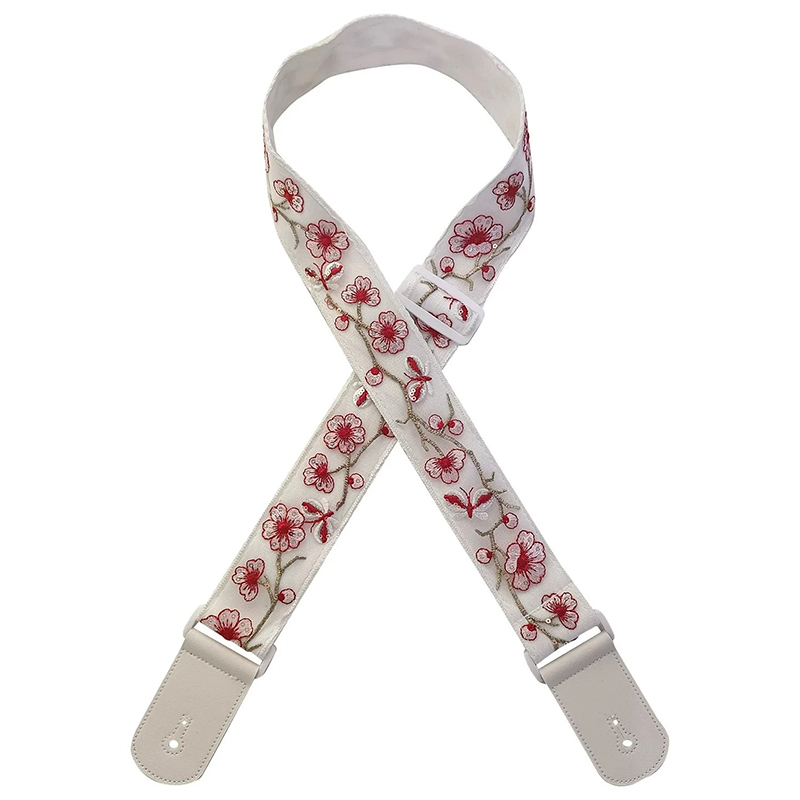 Sangle de guitare blanche avec motifs de fleurs de cerisier rouges et embouts en cuir synthétique gris clair.